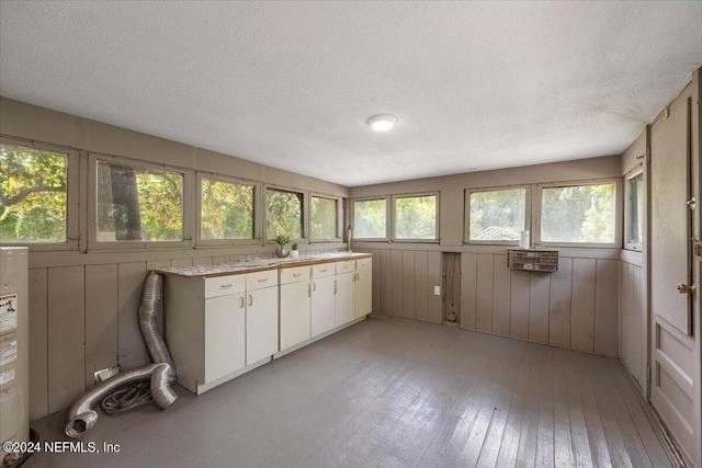 kitchen with white cabinetry, a textured ceiling, and light wood-type flooring