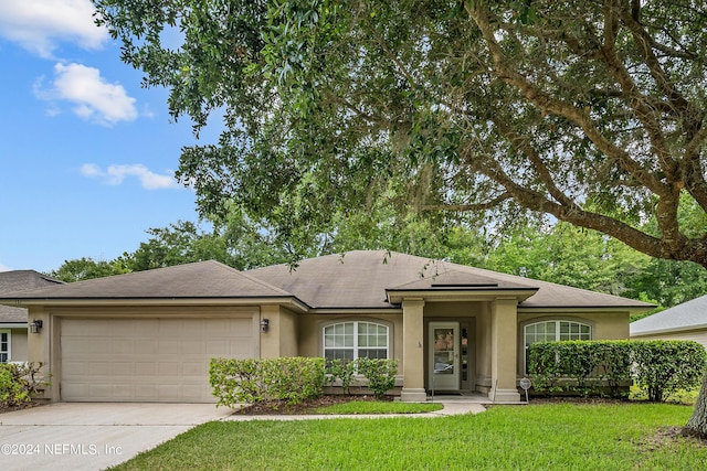 view of front of property featuring a front yard and a garage