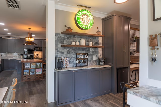 bar with hanging light fixtures, light stone counters, dark hardwood / wood-style flooring, and decorative backsplash