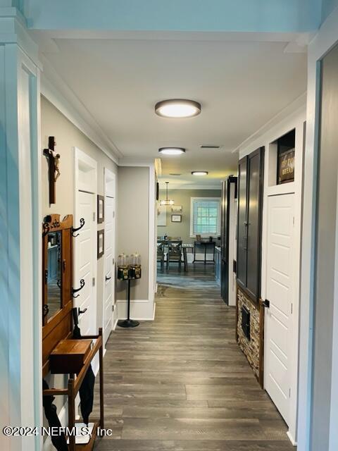 hall with dark hardwood / wood-style flooring and ornamental molding