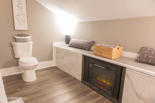 bathroom with lofted ceiling, wood-type flooring, and toilet