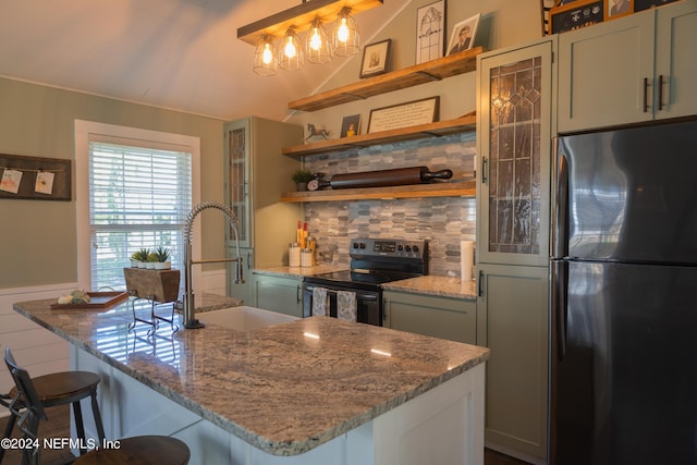 kitchen with sink, hanging light fixtures, light stone counters, black appliances, and a kitchen bar