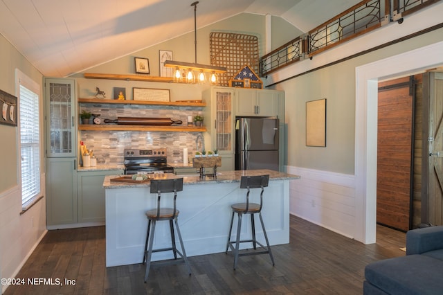 kitchen featuring stainless steel appliances, dark hardwood / wood-style floors, a kitchen breakfast bar, light stone countertops, and vaulted ceiling