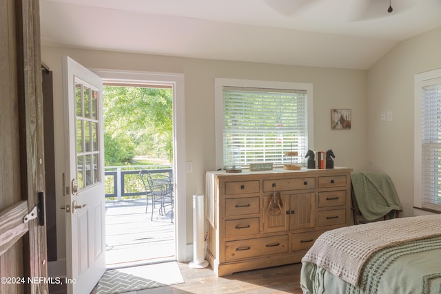 bedroom with multiple windows, vaulted ceiling, and access to exterior