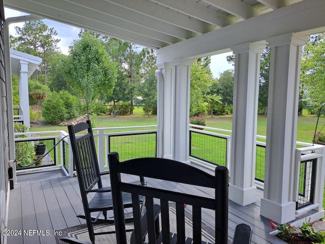 wooden deck featuring a lawn