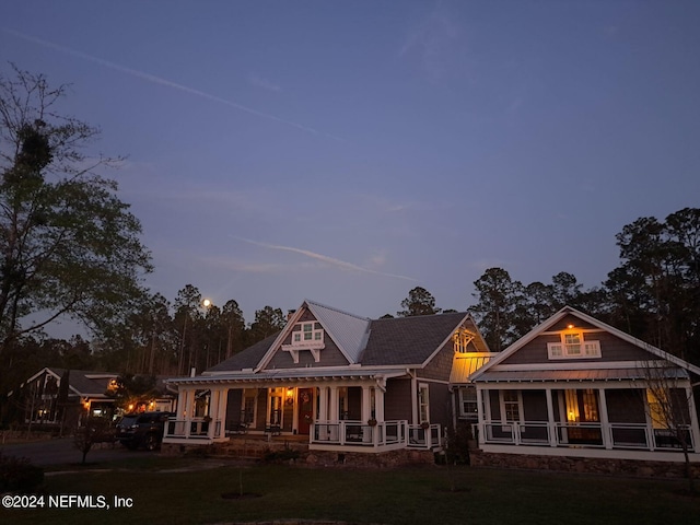 back house at dusk with a porch