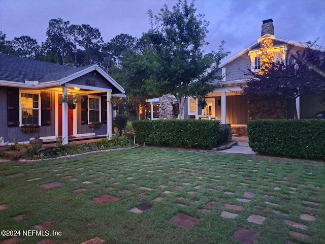 yard at dusk featuring a porch