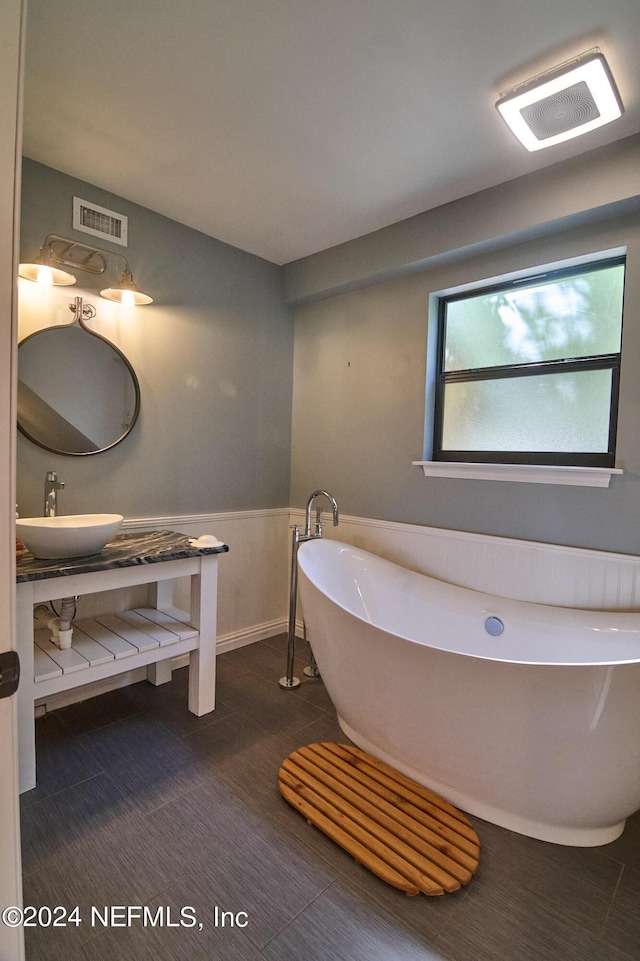 bathroom featuring sink and a washtub