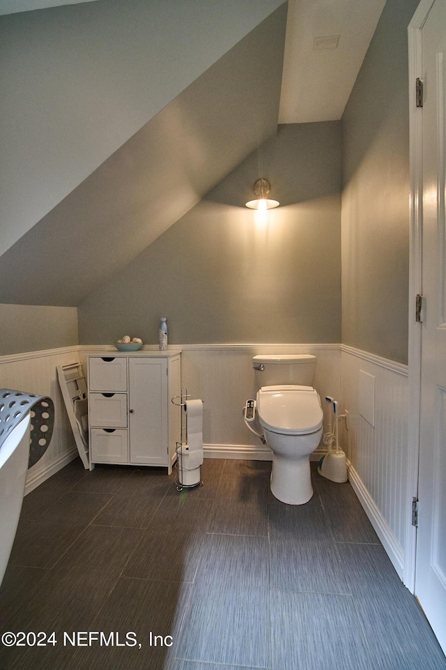 bathroom featuring lofted ceiling and toilet