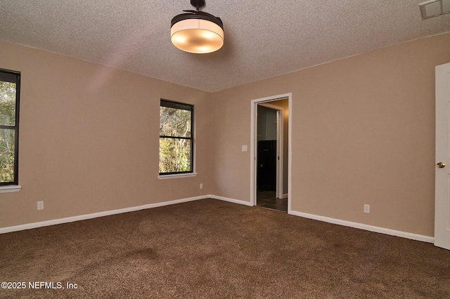 carpeted empty room with a textured ceiling