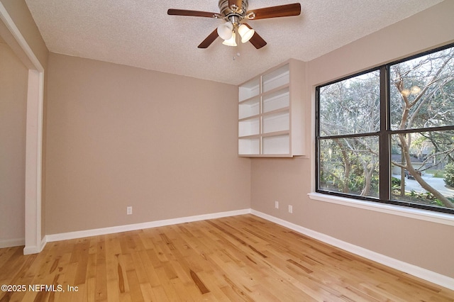 spare room with hardwood / wood-style flooring, ceiling fan, a textured ceiling, and a wealth of natural light