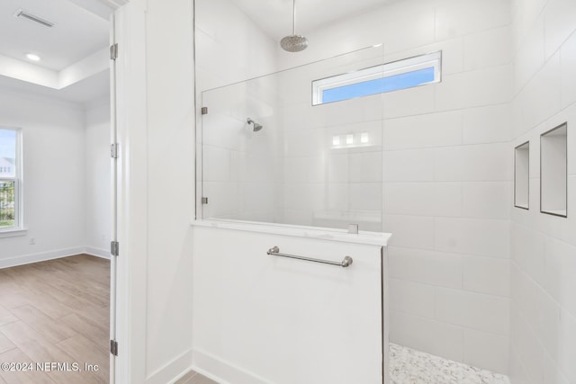 bathroom featuring hardwood / wood-style floors and tiled shower