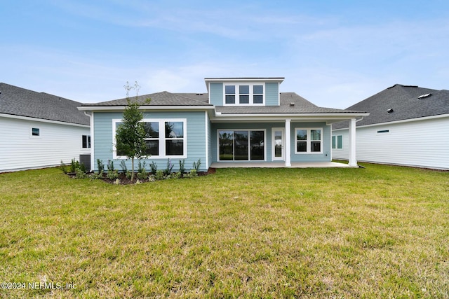 back of house featuring a patio area and a lawn