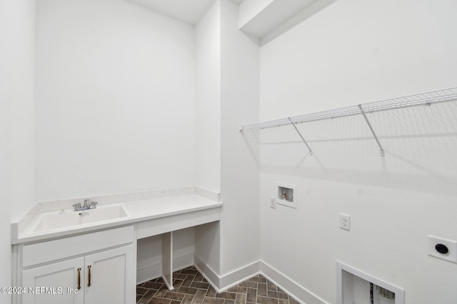 laundry area with hookup for an electric dryer, hookup for a washing machine, cabinets, and sink