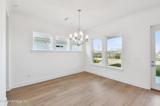 unfurnished dining area with hardwood / wood-style floors, a chandelier, and ornamental molding