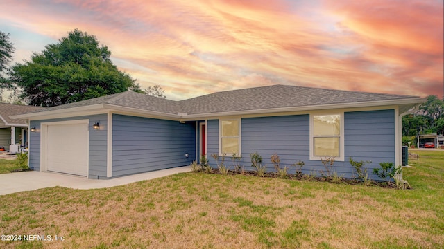 ranch-style house featuring a lawn and a garage