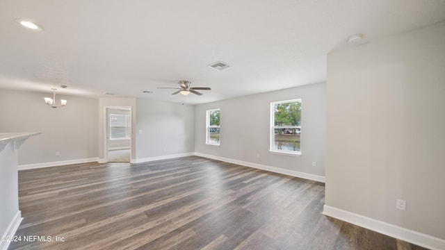 unfurnished living room with dark hardwood / wood-style flooring and ceiling fan with notable chandelier