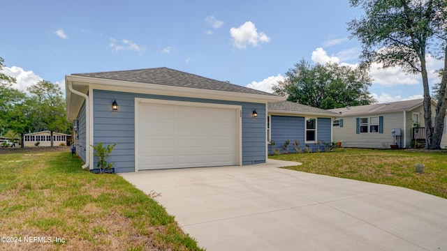 single story home with a garage and a front lawn