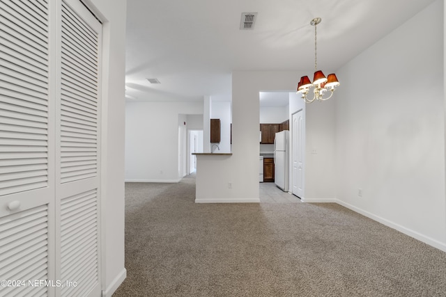 unfurnished living room featuring light colored carpet and a notable chandelier