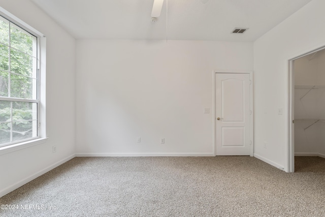 carpeted spare room featuring ceiling fan