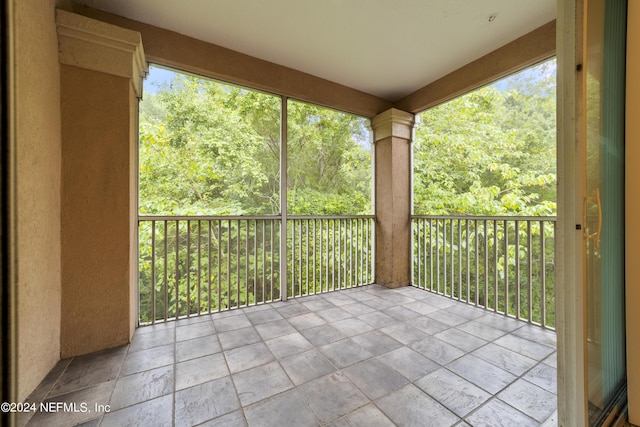 unfurnished sunroom with decorative columns