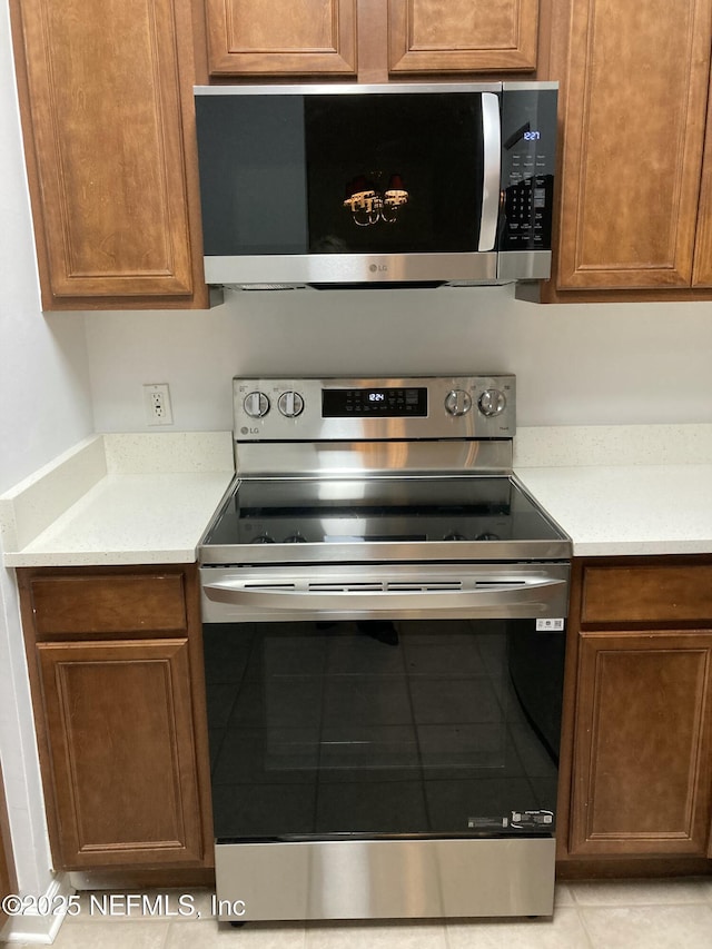 kitchen with light tile patterned floors and stainless steel appliances