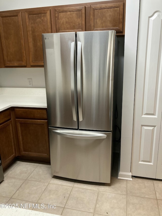 kitchen featuring light tile patterned floors and stainless steel fridge