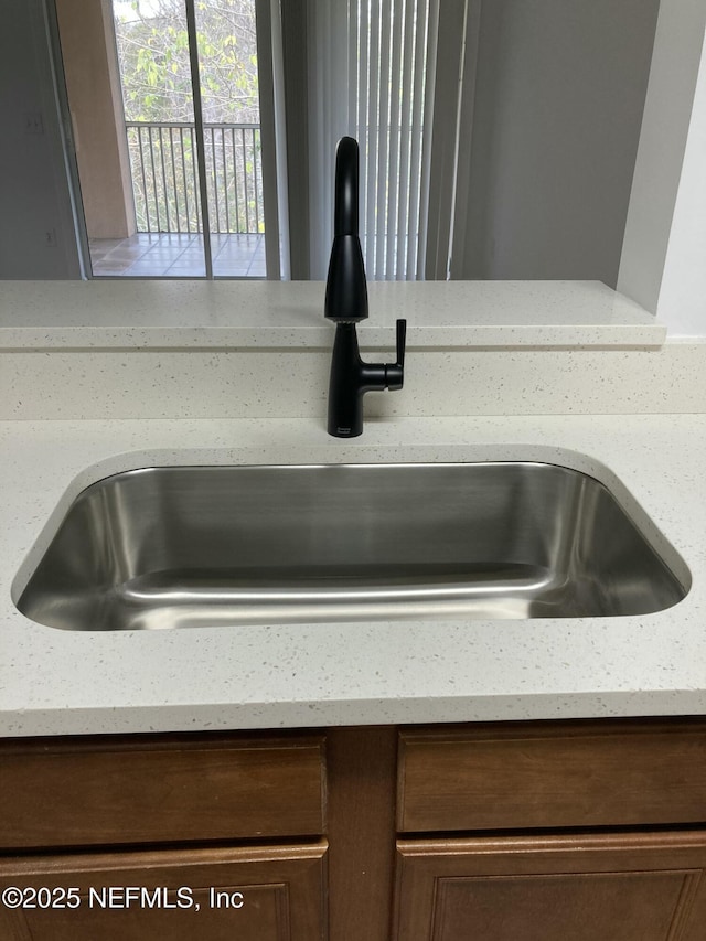 details featuring light stone countertops and sink