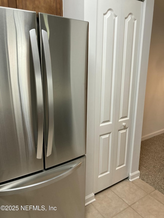 interior details featuring light colored carpet and stainless steel refrigerator