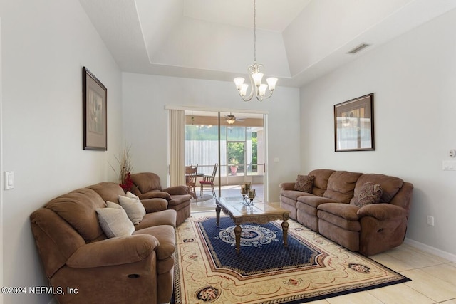 living room with a raised ceiling, light tile patterned flooring, and an inviting chandelier