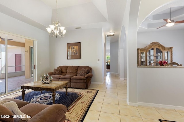 tiled living room with ceiling fan with notable chandelier and a wealth of natural light