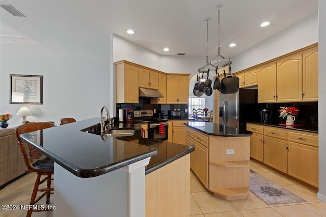 kitchen with a center island, backsplash, sink, appliances with stainless steel finishes, and kitchen peninsula