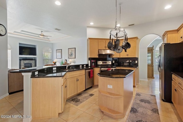 kitchen featuring kitchen peninsula, appliances with stainless steel finishes, sink, light brown cabinets, and a kitchen island