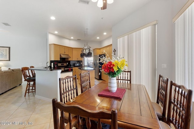 dining area featuring ceiling fan, sink, and light tile patterned floors