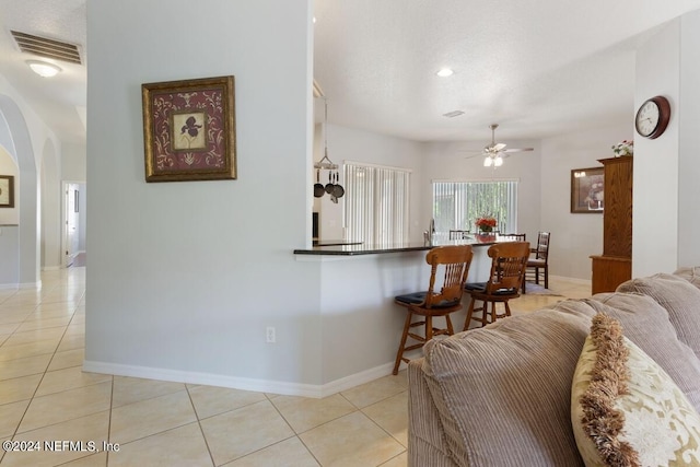 living room featuring ceiling fan and light tile patterned flooring