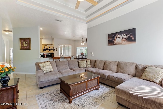 tiled living room with ceiling fan and a textured ceiling