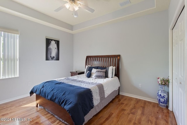 bedroom with hardwood / wood-style floors, ceiling fan, and a closet