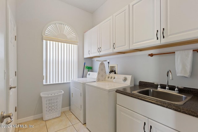 laundry area featuring washer and clothes dryer, light tile patterned flooring, cabinets, and sink