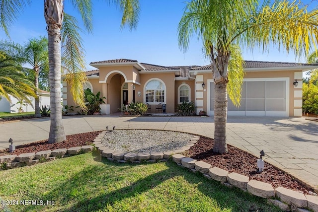 mediterranean / spanish-style home with a front yard and a garage