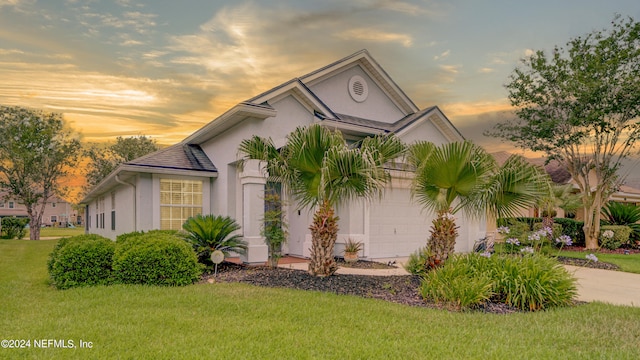 view of front of home with a garage and a yard