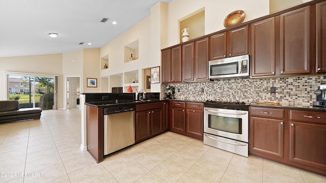 kitchen with sink, kitchen peninsula, tasteful backsplash, and appliances with stainless steel finishes