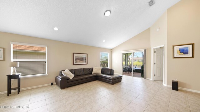 living room with high vaulted ceiling and light tile floors