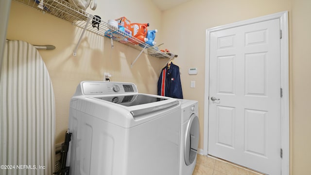 laundry room featuring washer and clothes dryer and light tile floors