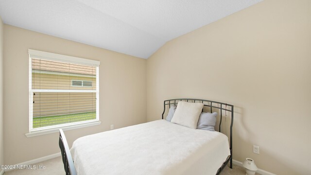 carpeted bedroom featuring lofted ceiling