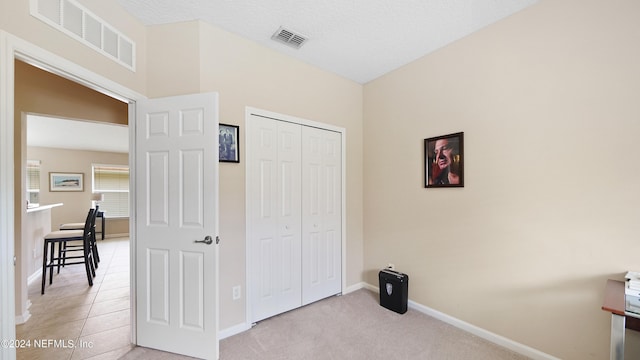 bedroom featuring a closet and light tile flooring