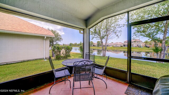 sunroom featuring a water view