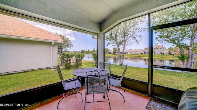 sunroom featuring a water view