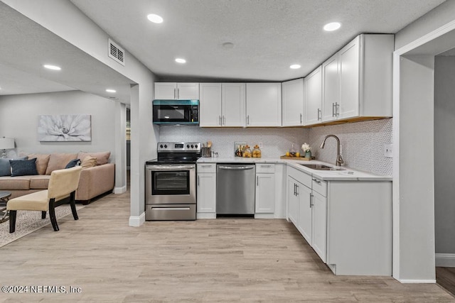 kitchen featuring white cabinets, appliances with stainless steel finishes, light hardwood / wood-style floors, and sink