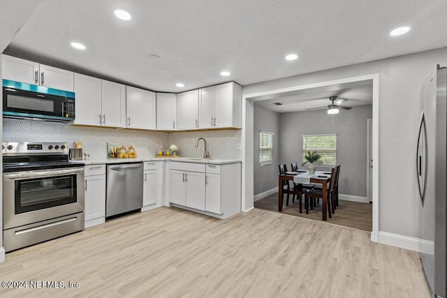 kitchen featuring white cabinets, light wood-type flooring, and stainless steel appliances