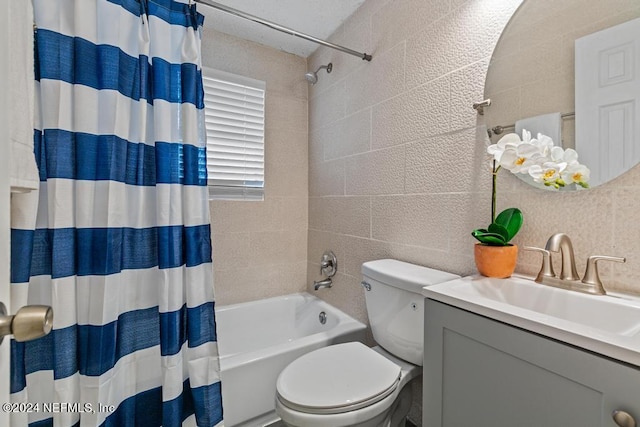 full bathroom featuring vanity, toilet, tile walls, and shower / bath combo with shower curtain